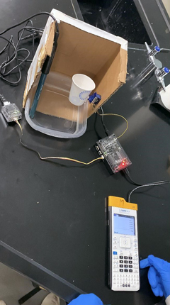 Figure 3. Engineering design project using the TI-Innovator™ Hub, TI-SensorLink Adapter and a servo motor. Based on pH values, the motor turned the cup to dump pH-lowering material. This activity was a modification from the TI STEM Project “Some Like It Tepid.”