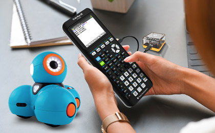 Lifestyle image with Dash, TI Bluetooth adapter and TI-84 Plus CE